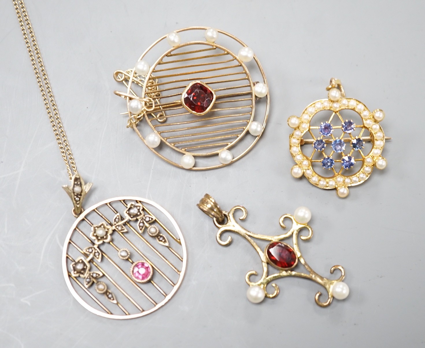 Three early 20th century yellow metal and gem set pendants or brooches, including sapphire and seed pearl, garnet and seed pearl and amethyst and seed pearl on chain and a later 375 garnet and cultured pearl set quatrefo
